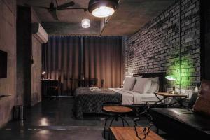sypialnia z łóżkiem i ceglaną ścianą w obiekcie Samantan Hotel at Nimman w mieście Chiang Mai