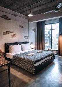 - une chambre avec un lit et une grande fenêtre dans l'établissement Samantan Hotel at Nimman, à Chiang Mai