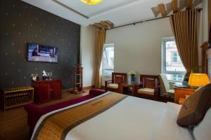 a bedroom with a bed and a tv on a wall at Vong Xua Boutique Hotel in Hanoi