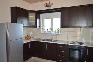 a kitchen with brown cabinets and a white refrigerator at Vasilopoulos Estate in Koroni