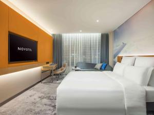 a hotel room with a large bed and a tv at Novotel Guangzhou Baiyun Airport in Huadu