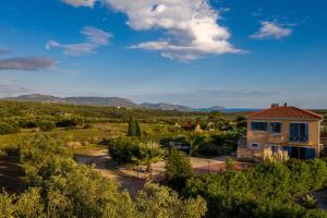 a house in the middle of a field with trees at Villa Finiki Messinia upstairs in Foiníki