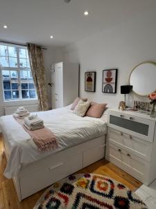 - une chambre avec un lit avec un miroir et une commode dans l'établissement Cozy flat London, à Londres