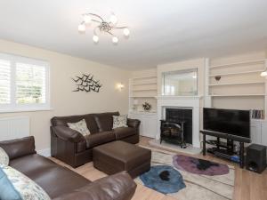 a living room with a couch and a fireplace at The Coach House in Wootton Bridge