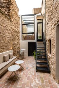 a patio with a couch and tables and a staircase at ABBI SUITES Casa Rural, Suites & Spa in Bocairent