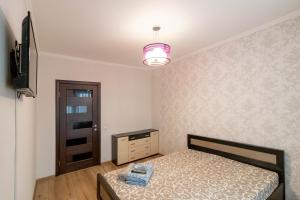 1 dormitorio con 1 cama, vestidor y TV en Kvartirkoff na Geroev Dnepra 36 b en Kiev