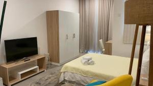 um quarto de hotel com uma cama e uma televisão de ecrã plano em Studio 104 Ebene Square Urban Living Apartments em Ebene