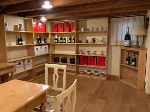 una habitación con una mesa y estanterías de botellas de vino en La Valdella, en Valdobbiadene