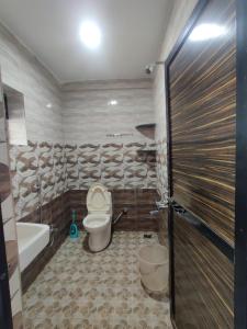 ein Badezimmer mit einem WC, einer Badewanne und einem Waschbecken in der Unterkunft Mary Joey in Baga