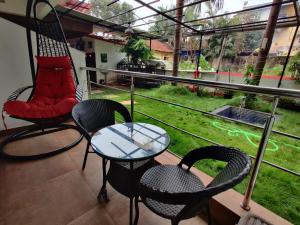 a balcony with a table and chairs and a view of a yard at Mary Joey in Baga