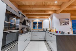 勒莫內蒂耶萊班的住宿－Chalet Aigle，一间大厨房,配有白色家电和木制天花板