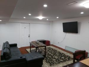 a living room with a couch and a flat screen tv at Guest House Room No 02 in Mississauga