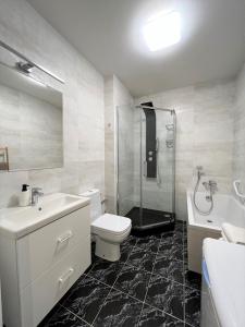 La salle de bains est pourvue de toilettes, d'un lavabo et d'une douche. dans l'établissement VIU Seaside Residence, à Sopot