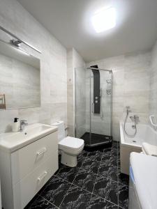 a bathroom with a toilet and a sink and a shower at VIU Seaside Residence in Sopot