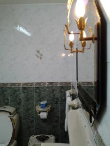 a bathroom with a toilet and a sink and a mirror at Sophia Hotel in Dar es Salaam