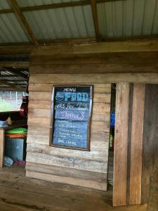 una señal en el lateral de una pared de madera en Natural House Farm Stay, en Môndól Kiri 31 fotos más