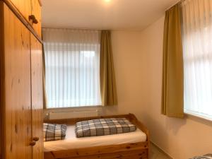 - une petite chambre avec un lit et une fenêtre dans l'établissement Jordsand, à Horumersiel