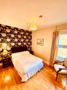 a bedroom with a large bed and a chair at Homerton House Apartments in Cambridge