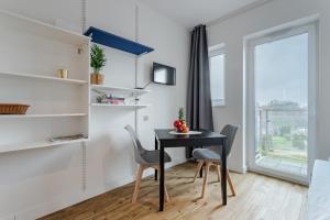 jadalnia ze stołem i krzesłami oraz oknem w obiekcie Apartament Monika w Poznaniu