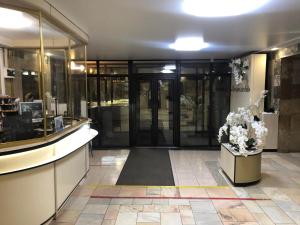 vestíbulo de un edificio con puertas de cristal y flores en Готель Профспілковий, en Vínnytsia