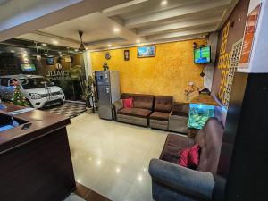 Una sala de estar con un sofá y un televisor. en Chalil Residency, en Ernakulam