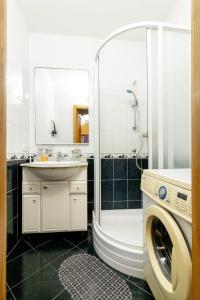 een badkamer met een douche en een wasmachine bij Kvartirkoff na Levka Lukyanenko 3v in Kiev