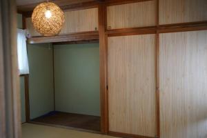um armário com portas de madeira e uma luz suspensa em 吉田邸　古民家の落ち着いたお家 