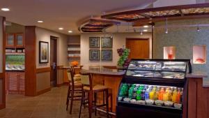 a restaurant with a bar with a drink cooler at Sonesta Select Austin North Central in Austin
