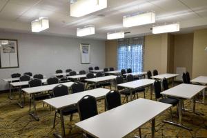 Comfort Inn & Suites Houston I-45 North - IAH في هيوستن: غرفه فاضيه فيها طاولات وكراسي واضاءات