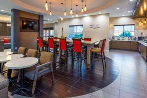 un restaurante con un bar con mesas y sillas rojas en Comfort Inn & Suites Houston I-45 North - IAH, en Houston