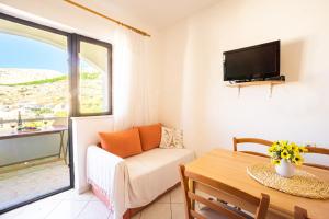 een woonkamer met een bank en een tafel bij Apartment and Room Bacic in Metajna