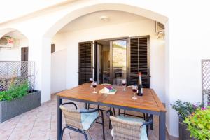 a table on a patio with glasses of wine at Apartment and Room Bacic in Metajna