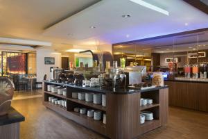 a restaurant with a counter with dishes on it at BW Kemayoran Hotel & Convention Powered by Archipelago in Jakarta