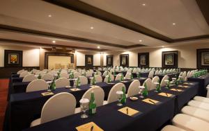 een conferentieruimte met lange tafels en stoelen bij BW Kemayoran Hotel & Convention Powered by Archipelago in Jakarta