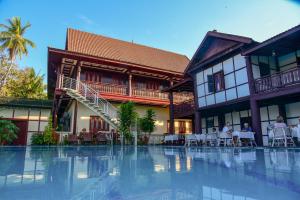 un complexe avec une piscine en face d'un bâtiment dans l'établissement Senesothxuene Hotel, à Muang Không