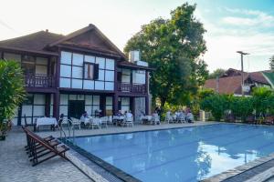 a hotel with a swimming pool in front of a building at Senesothxuene Hotel in Muang Không