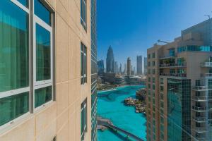 uitzicht op een rivier tussen twee hoge gebouwen bij Splendid Apartments with Burj Khalifa and Fountain View in Dubai