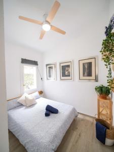 a bedroom with a bed with a ceiling fan at Seafront Modern Villa to Relax and Disconnect in Cala en Bosc