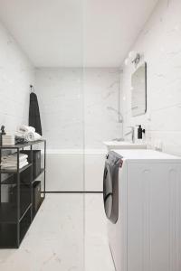 a white bathroom with a sink and a refrigerator at W Apartments Uus-Hollandi with sauna in Tallinn