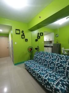 ein Schlafzimmer mit einem Bett in einem Zimmer mit grünen Wänden in der Unterkunft SEA RESIDENCES Yeshua in Manila