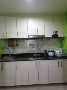 a kitchen with white cabinets and a sink at SEA RESIDENCES Yeshua in Manila