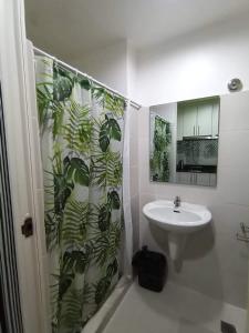 a bathroom with a shower curtain with a sink at SEA RESIDENCES Yeshua in Manila