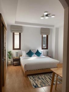 1 dormitorio con 1 cama grande con almohadas azules en Benjamin's Hut, en Srithanu