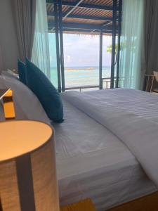 1 dormitorio con 1 cama y vistas al océano en Benjamin's Hut, en Srithanu