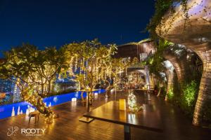 eine Terrasse mit Weihnachtslichtern und Bäumen sowie einem Tisch in der Unterkunft The Myst Dong Khoi in Ho-Chi-Minh-Stadt