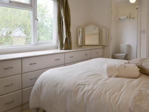 een witte slaapkamer met een bed en een raam bij Acacia in Thornbury