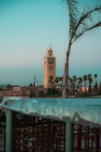 um edifício com uma torre de relógio ao fundo em Riad Lalla Mimouna em Marrakech
