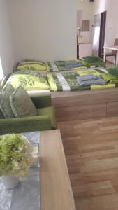 two beds in a room with a table and a couch at Kapitula centrum in Banská Bystrica