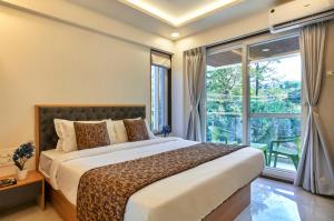 マハバレシュワールにあるDrizzle Resort Mahabaleshwarのベッドルーム1室(ベッド1台、大きな窓付)