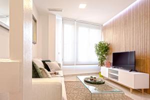 a living room with a couch and a tv at Genteel Home Magdalena in Seville